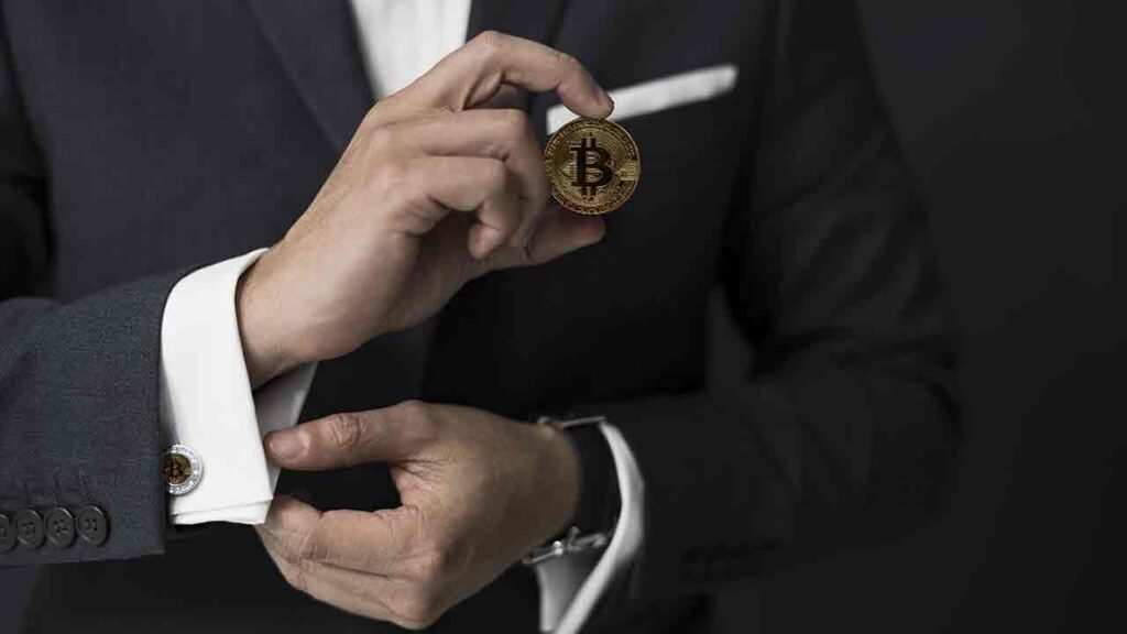 Pildil on mees hoidmas bitcoini, mis illustreerib teemat Kahtlustatav bitcoini looja Adam Back näeb bitcoini tõusu