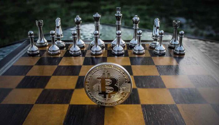 Pildil on malelaud koos bitcoini mündiga, mis ilustreerib teemat Malelegend Kasparov näeb bitcoinis tulevikku